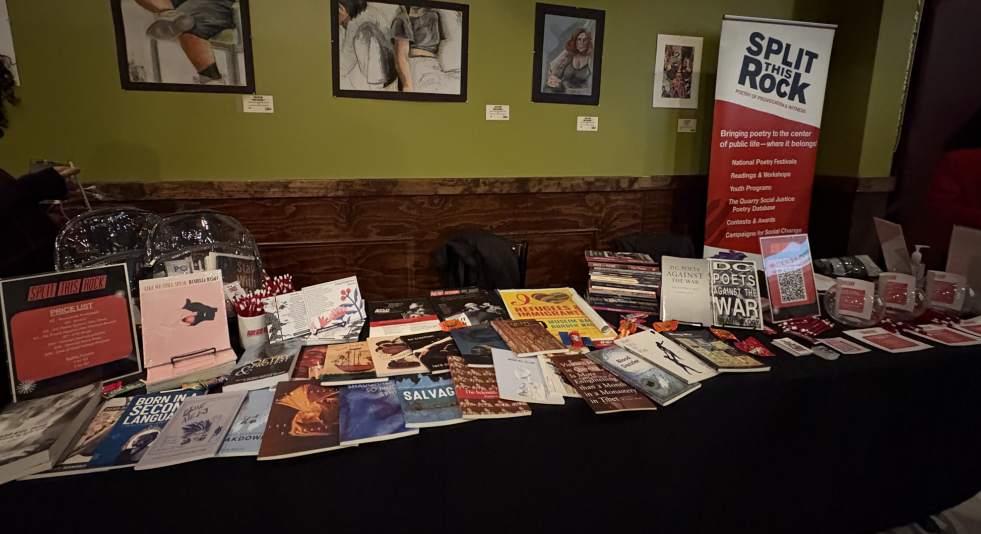 A long table with a black tablecloth covered with Split This Rock merch and books. 