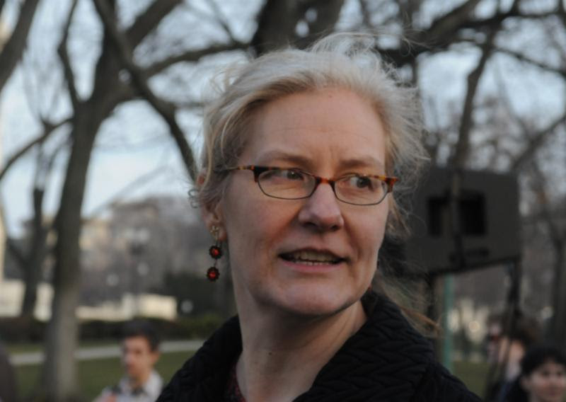 Photo of Sarah slightly looking behind her with a slight smile on her face